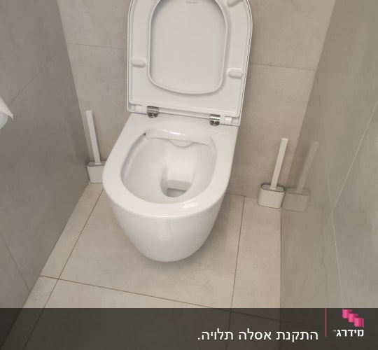 אסלה לבנה עם מכסה פתוח ומברשות ניקוי